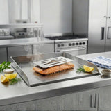 Salmon being cooked on a grill pan in a kitchen setting