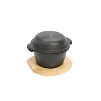 Black cast iron pot on a wooden board