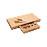 A 5-piece bamboo cheese set with a board, fork, knife, and three cheese knives, all made of bamboo, displayed with the cheese knives in a drawer.