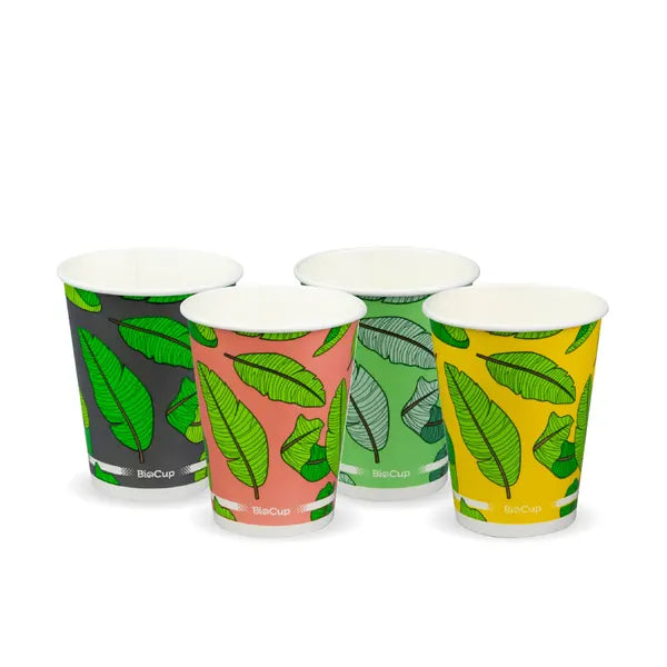 A set of three disposable paper cups with different colored leaf patterns on a white background.