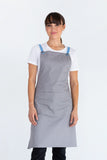 A person wearing a light gray bib apron with blue straps over the shoulders.