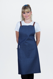 A person wearing a blue bib apron with tan straps and a pocket, over a white t-shirt.