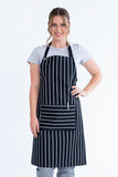 A person wearing a black and white striped bib apron with a front pocket.