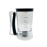 Clear measuring cup with black handle and measurement markings on a white background