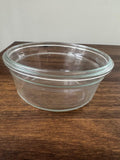 Clear glass bowl on a wooden surface with a plain background