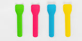 A set of four colored paper gelato spoons in green, pink, blue, and yellow, against a white background.
