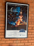 Framed 'Star Wars' movie poster on a brick wall