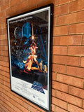 Framed 'Star Wars' movie poster on a brick wall
