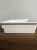White plastic bin with gray lid on a wooden surface