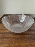 Frosted glass bowl with leaf pattern on a wooden surface