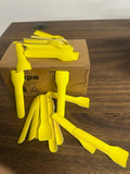 Yellow paper ice cream spoons items on a cardboard box on a wooden surface